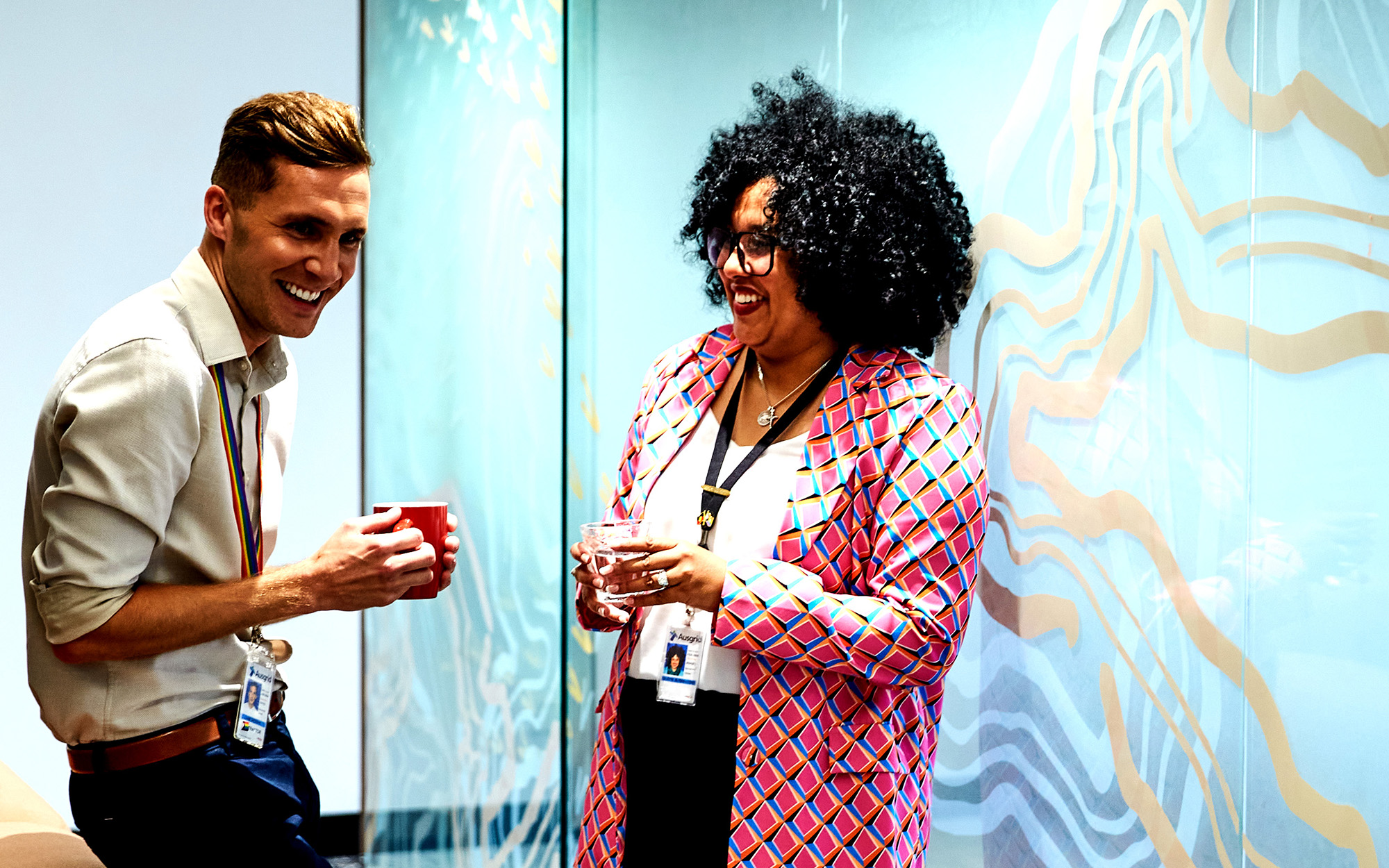 Two Ausgrid Employees catching up over coffee outside a meeting room